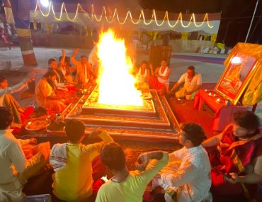 baglamukhi havan puja maha yagya by our pandit ji -Baglamukhi Havan: A ritualistic fire burning during a Baglamukhi Havan ceremony, with people sitting around it performing sacred chants and offerings.